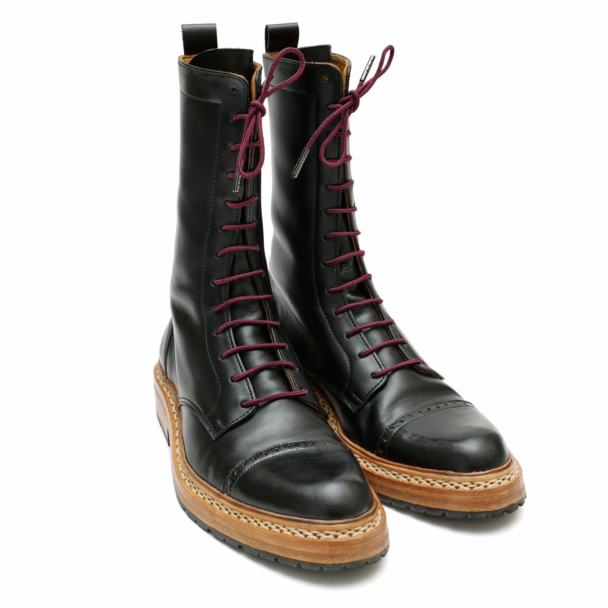 Custom made black leather combat boots with burgundy laces in front of white backdrop. 
