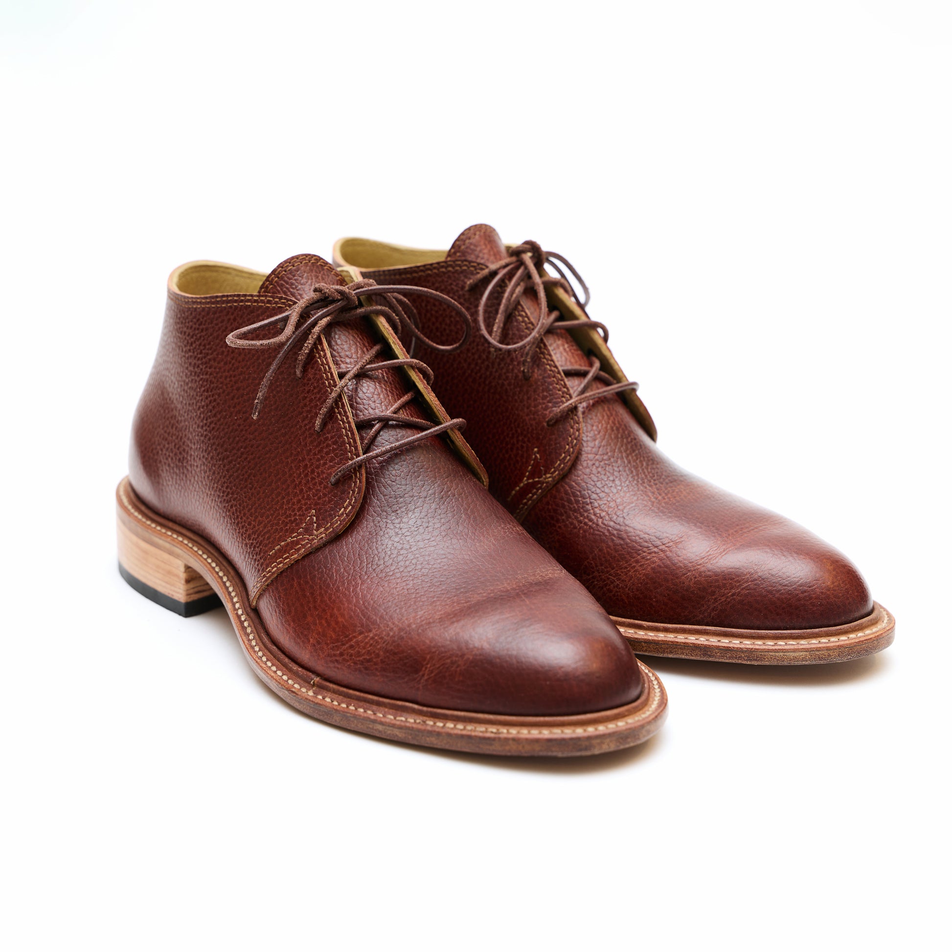 Handmade bespoke brown leather Chukka boots on white background. 