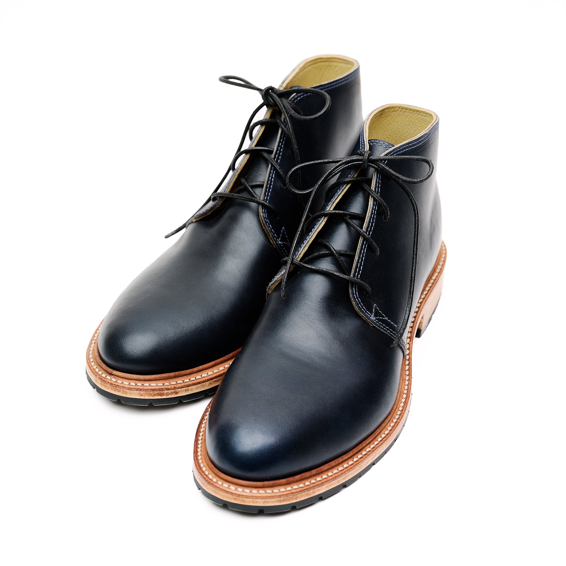 Handmade bespoke black leather Chukka boots on white background. 
