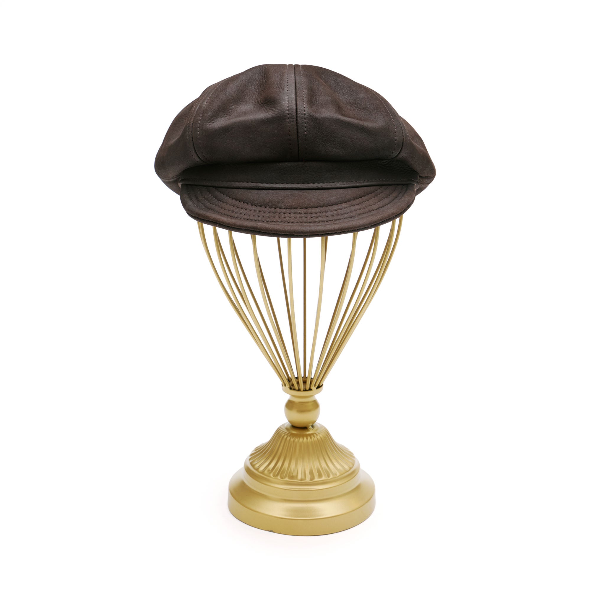 Brown leather newsboy hat on gold hat stand. 