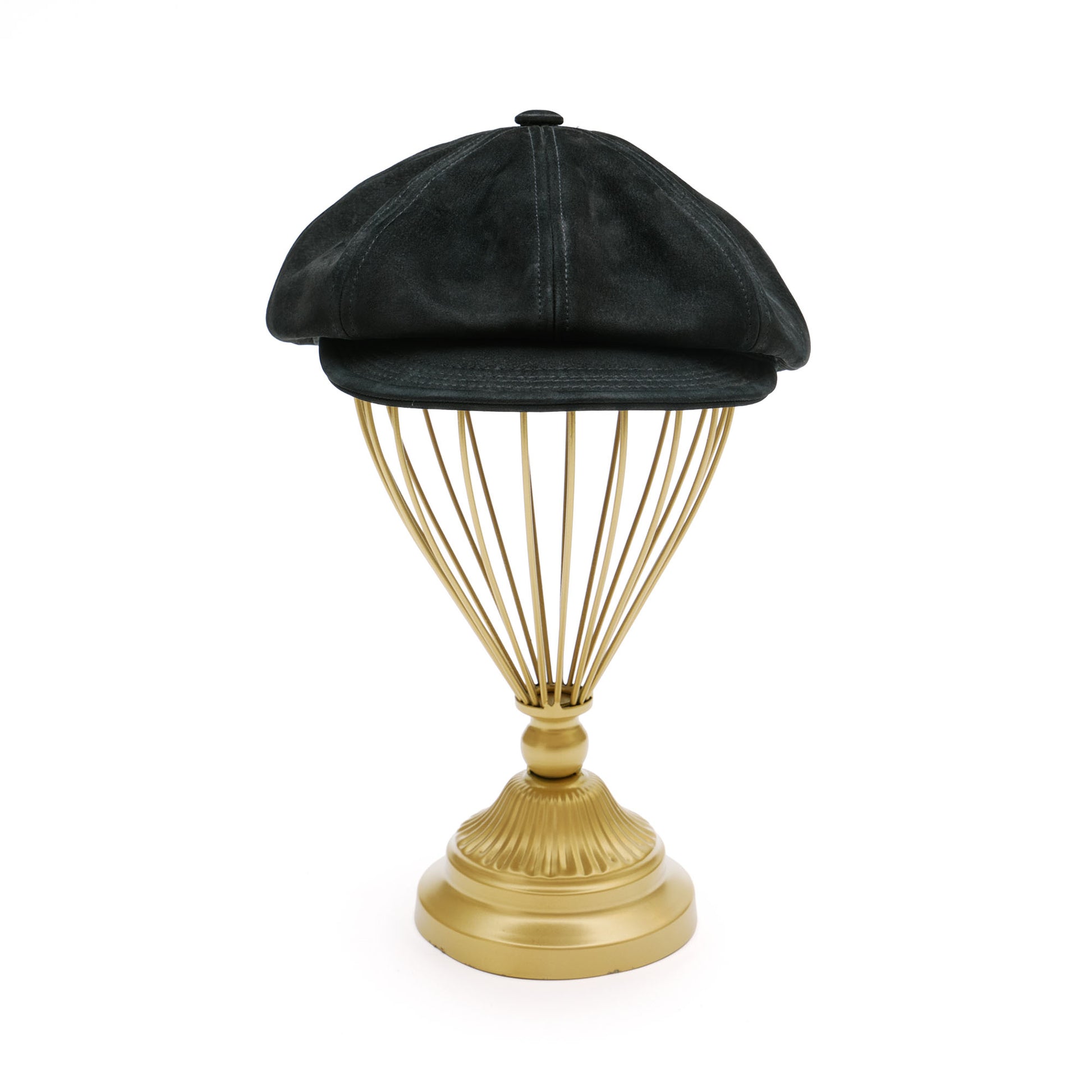 Black leather newsboy hat on gold hat stand. 