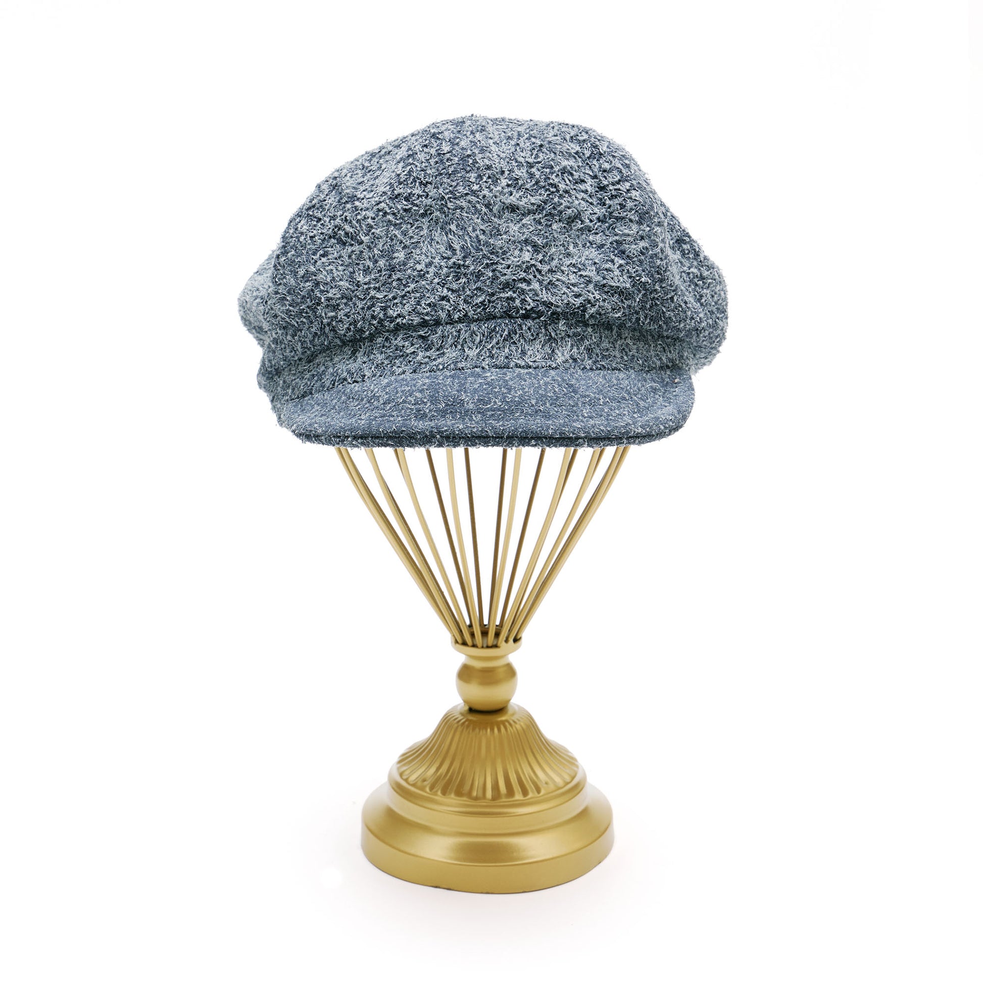 Grey suede melton cap on  gold hat stand in front of white background. 