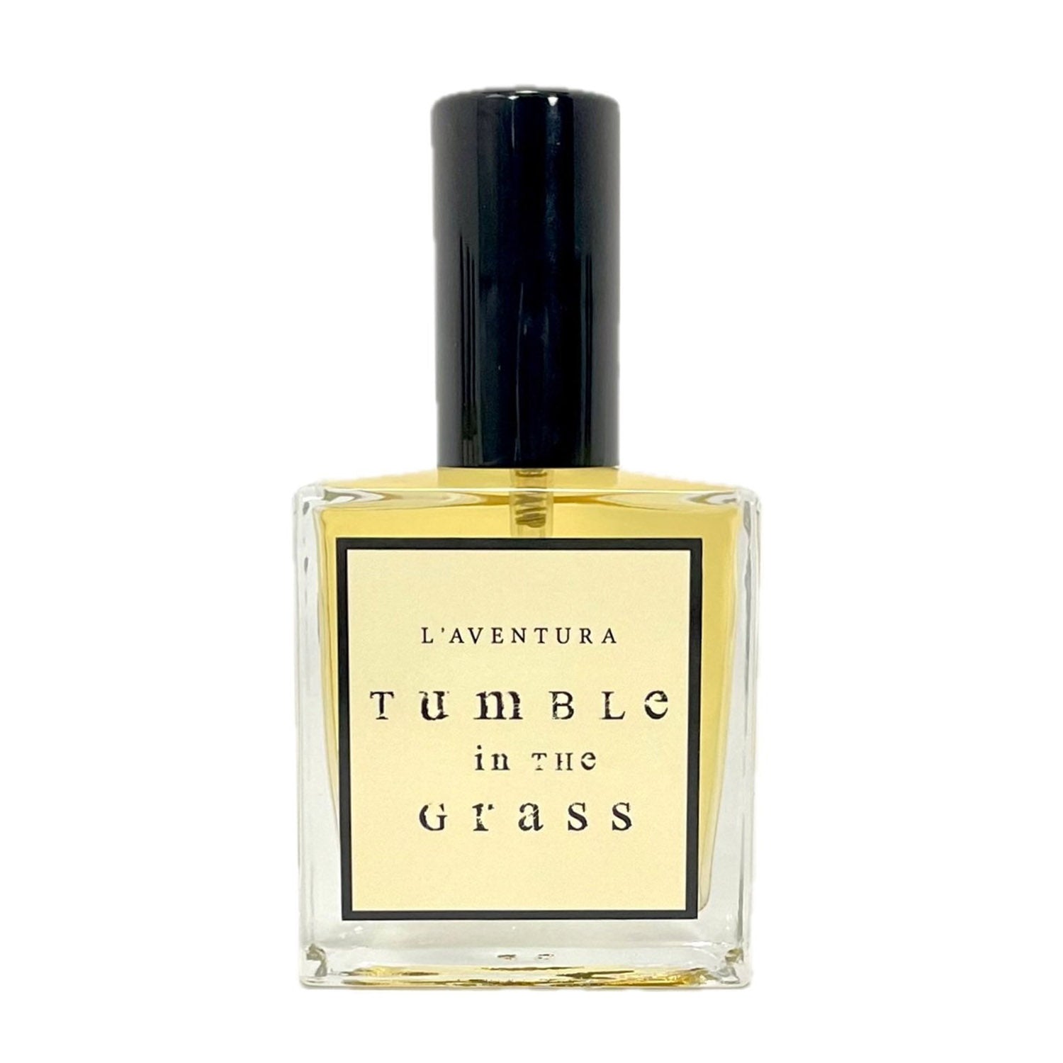 Bottle of L'Aventura "Tumble in the Grass" perfume against white background. 