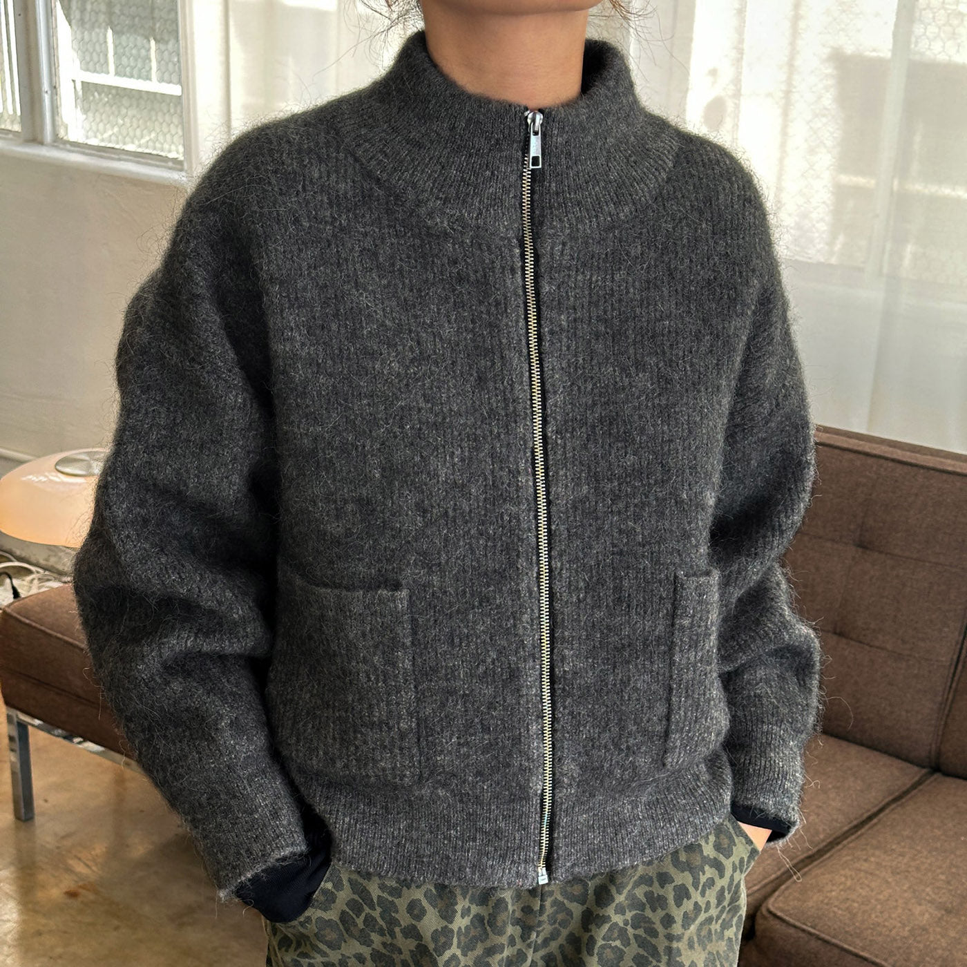 Person wearing zip up dark grey alpaca wool sweater. 