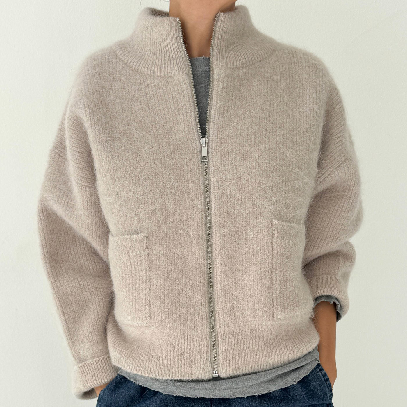 Person wearing zip up beige alpaca wool sweater. 