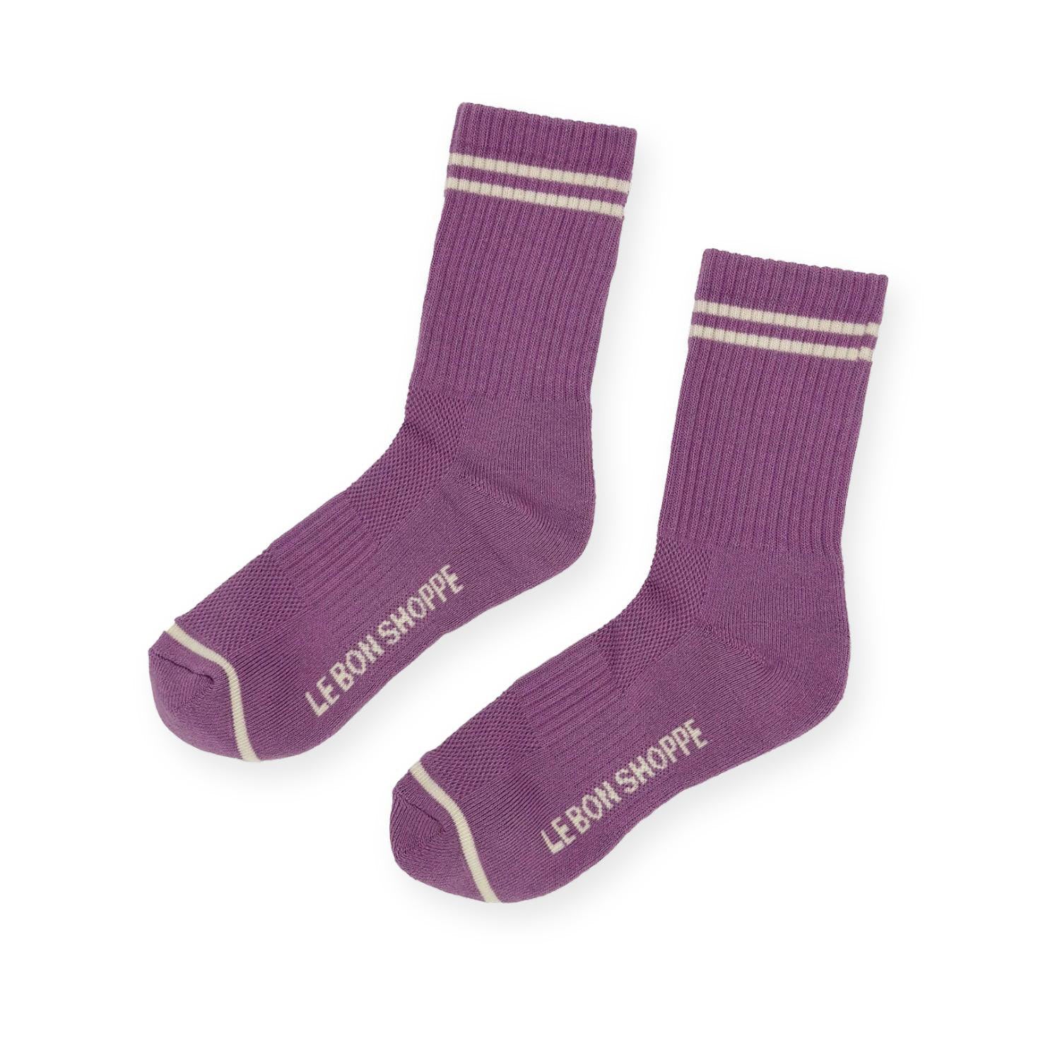 Pair of purple ribbed sport socks with double white stripe around ankle and "Le Bon Shoppe" on soul. 