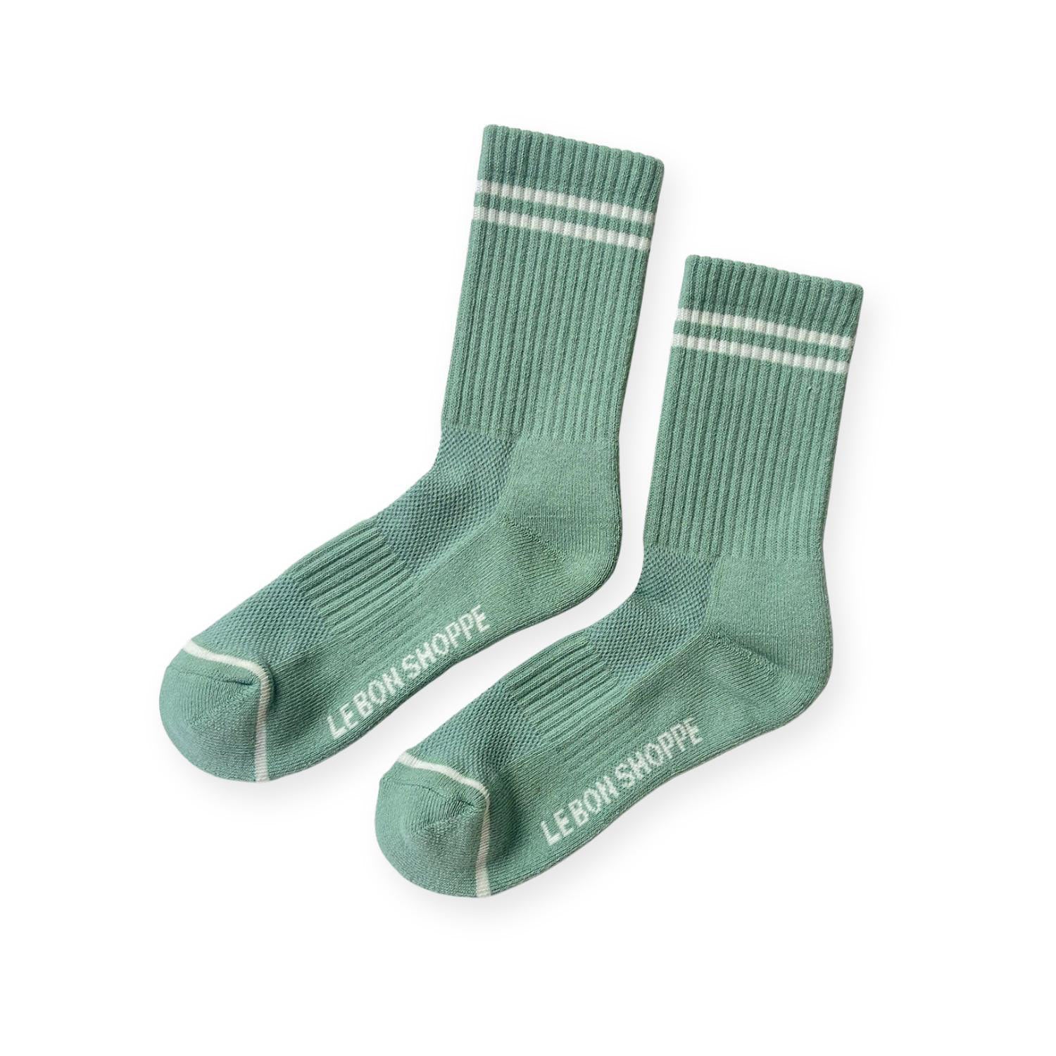 Pair of green ribbed sport socks with double white stripe around ankle and "Le Bon Shoppe" on soul. 