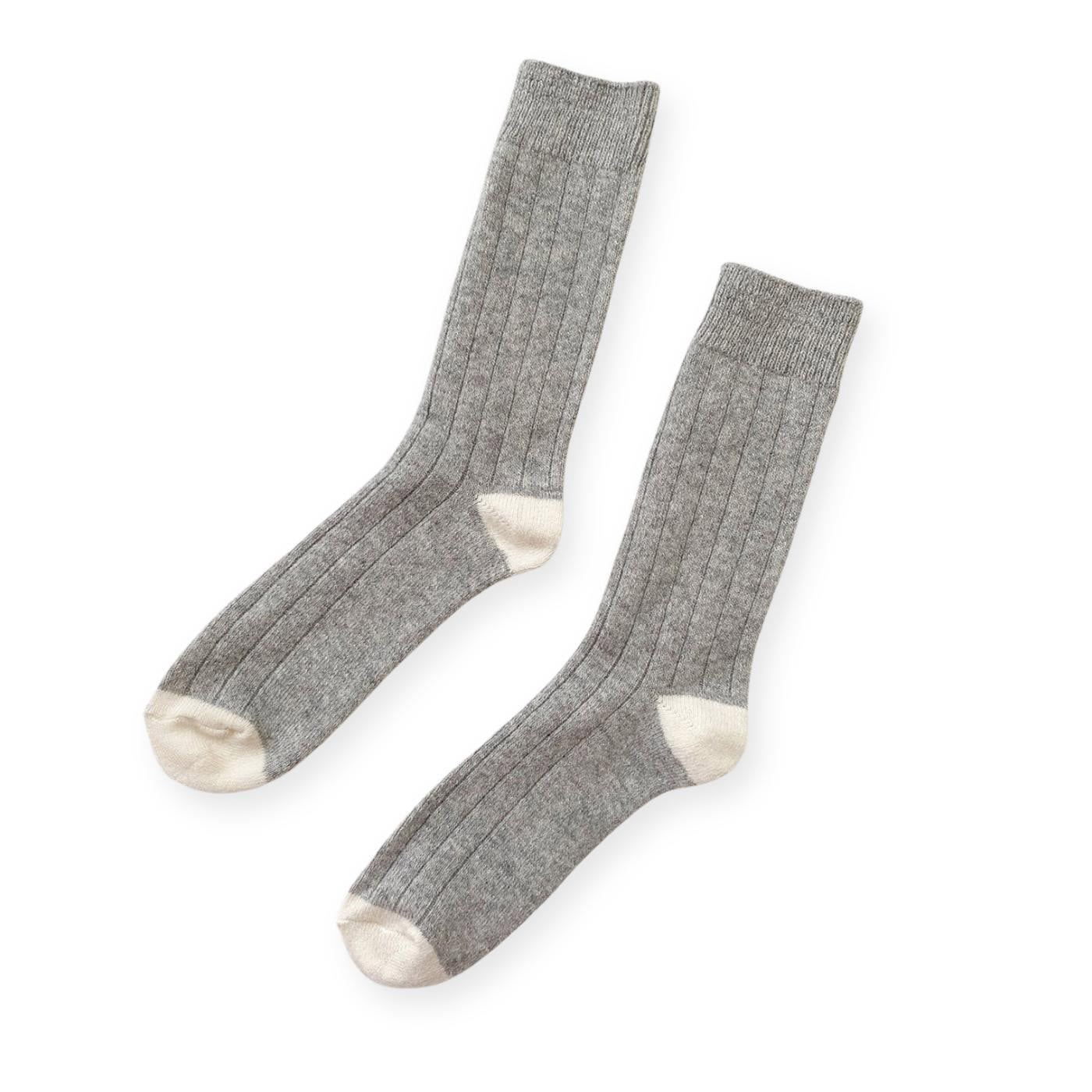 A pair of grey ribbed cashmere socks with white toes and heels. 