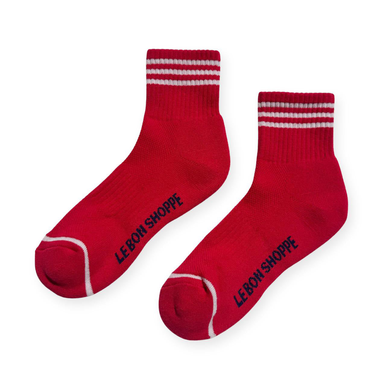 Pair of red sport socks with white stripes on ankle and Le Bon Shoppe text on soul. 