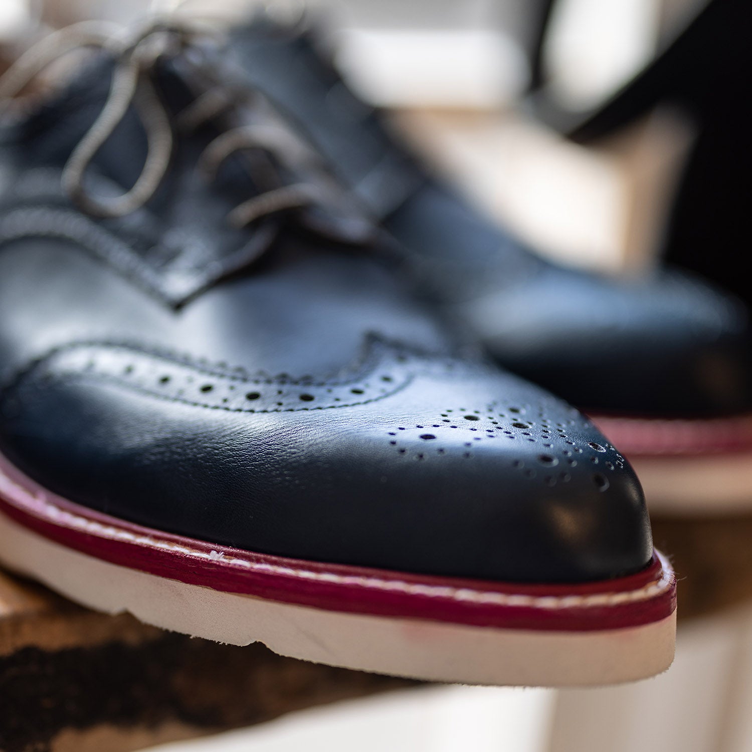Close-up of navy custom leather brogue oxford shoes by Leolo. 
