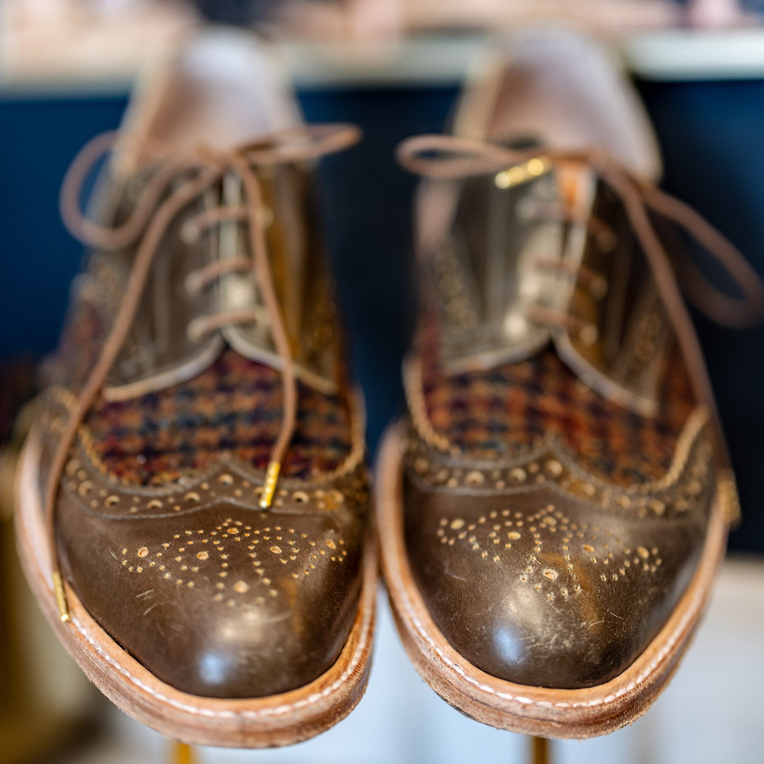 Olive green and plaid custom hand made leather oxford shoes by Leolo with blurred background. 