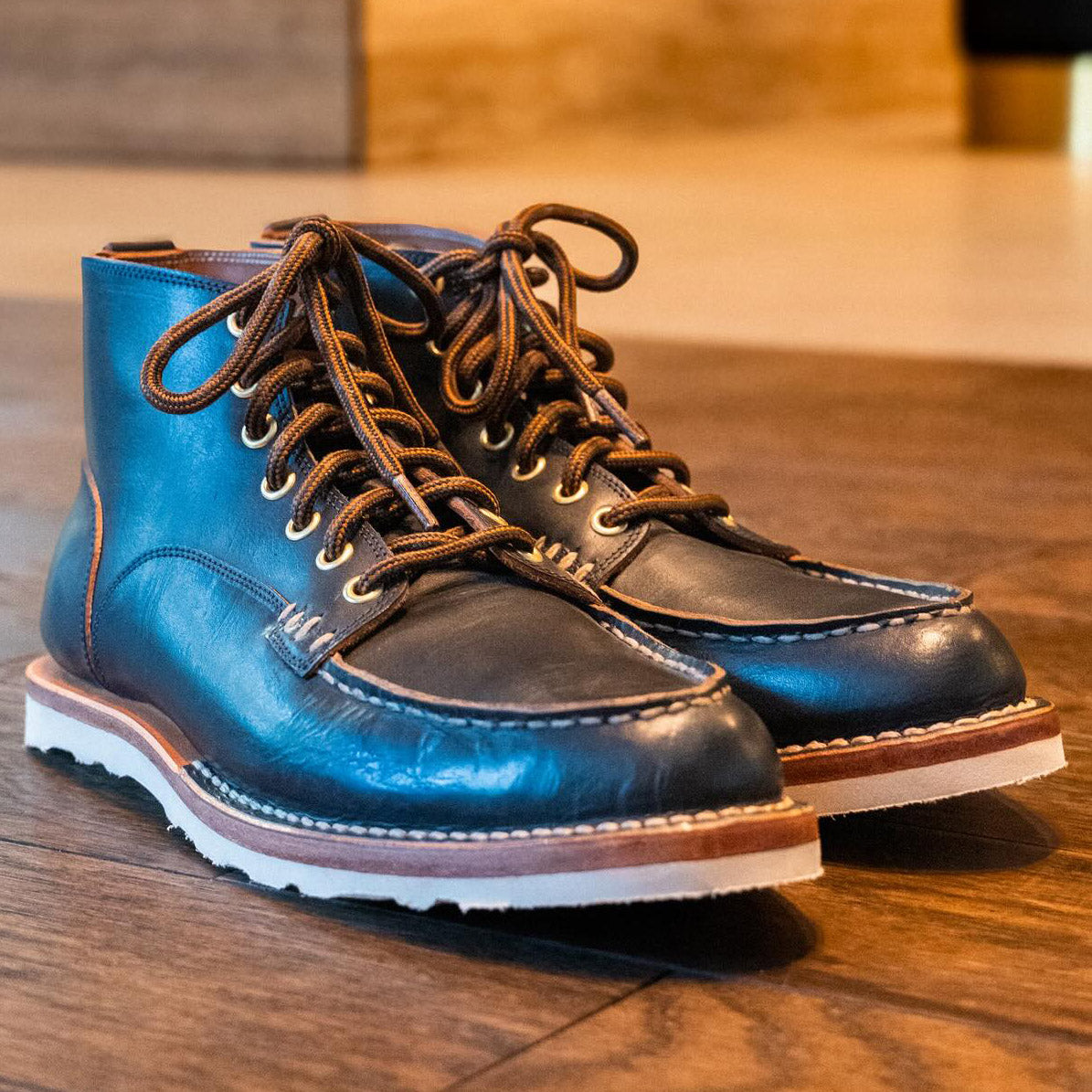 Black custom hand made leather work boots by Leolo, with sun shining on them. 