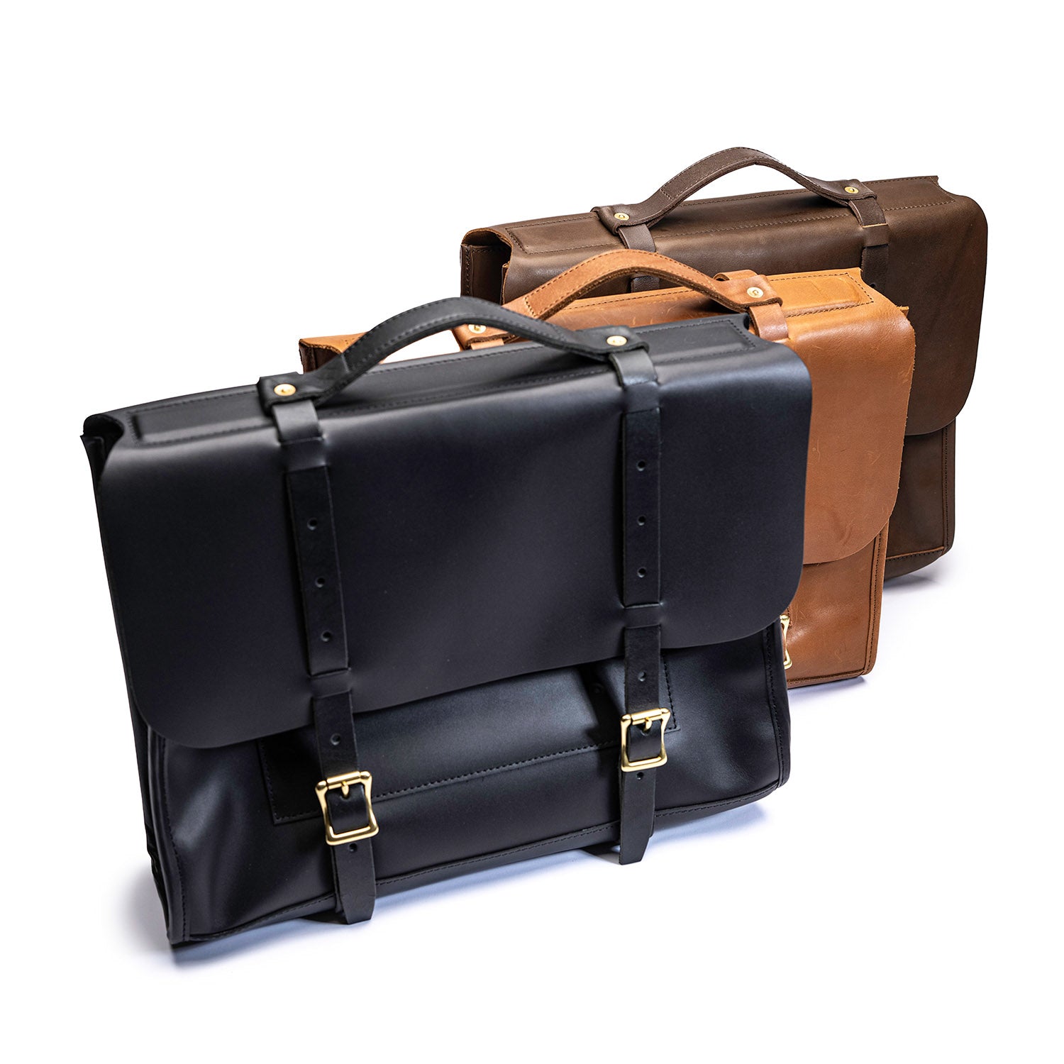 Three Leolo eather messenger bags (black, tan and brown) with strap and brass harware closure lined up in front of white background. 