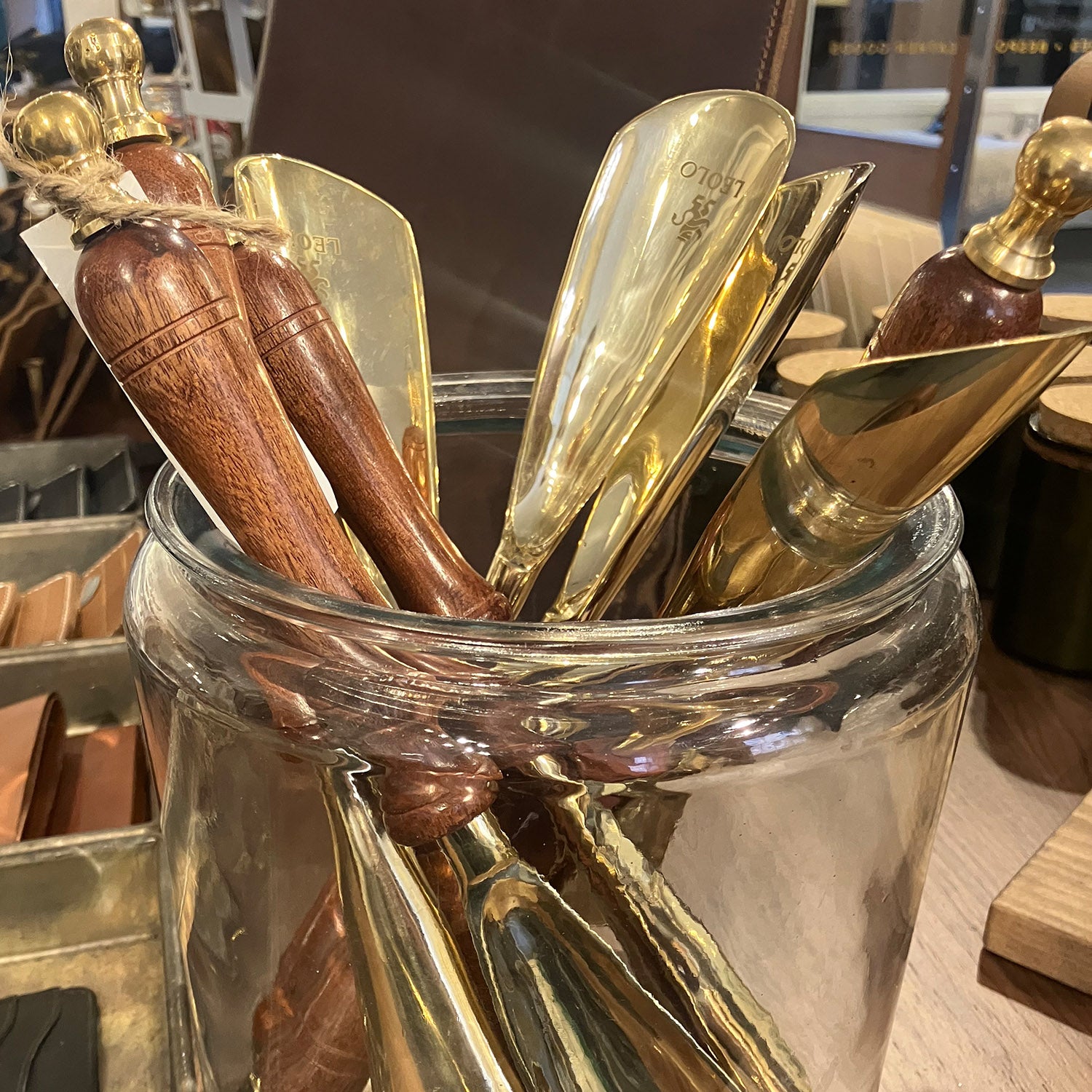 Glass jar with small Leolo branded portable shoe horns. 