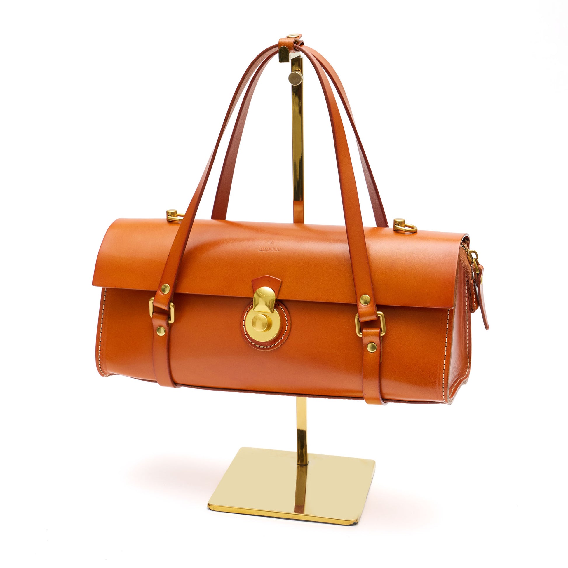 Tan leather rectangle handbag with brass hardware. 
