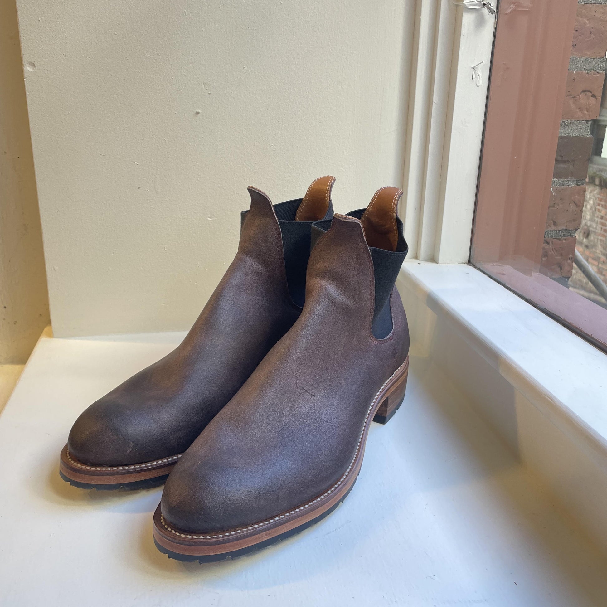 Pair of brown leather chelsea style boots by Leolo on a white surface with a neutral background